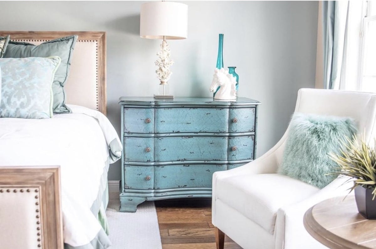farmhouse bedroom furniture including accent chair, side table, dresser and queen size bed with blue accents