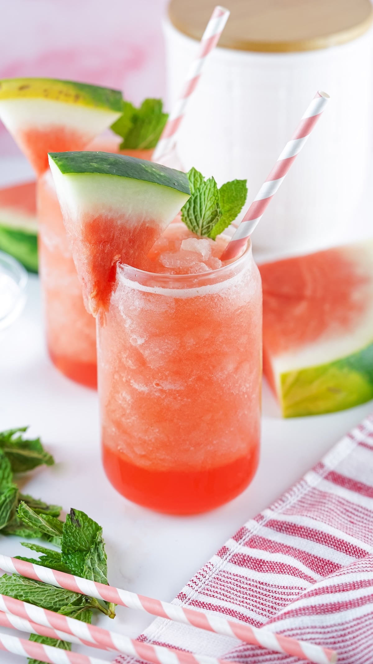 Mason jar watermelon slushies with mint and watermelon slices.